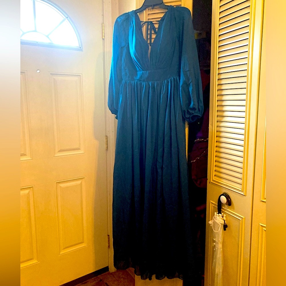 New with tags floor length teal gown with sheer long sleeves, size 8.